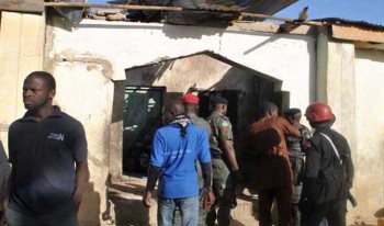 People gather at a damaged building following an attack by Boko Haram in Maiduguri, Nigeria Monday, Dec. 28, 2015. Boko Haram Islamic extremists struck the northeastern Nigerian city of Maiduguri for the first time in months Monday with rocket-propelled grenades and multiple suicide bombers, witnesses said. At least 50 people were killed and the death toll could go higher. (AP Photo/Jossy Ola)